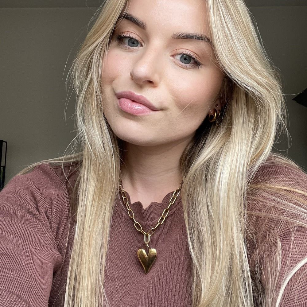 Jonge vrouw met waterproof stainless steel ketting met groot hart, de ketting is verkrijgbaar in het goud en in het zilver. Bestel de ketting nu op www.jenelry.com
