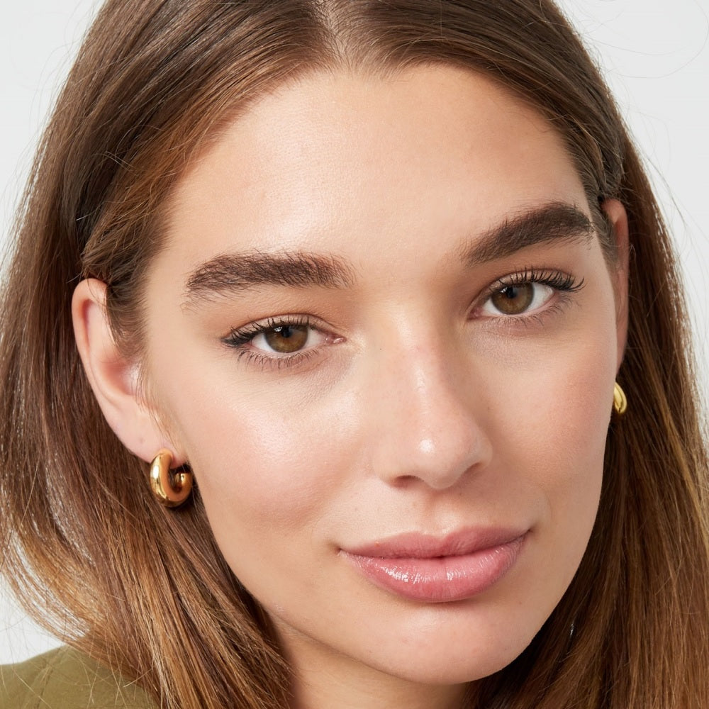 meisje met grove gouden oorbellen, dikke kleine hoops in het goud