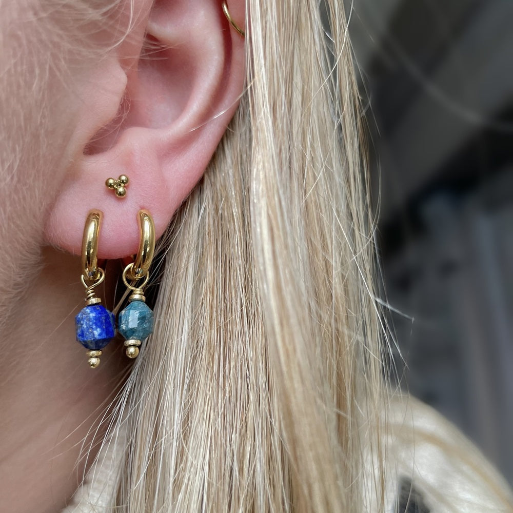 Oorbellen Eden Blue bestaan uit een oorringetje met een gekleurde donkerblauwe steen als bedel. De oorbellen zijn gemaakt van stainless steel, hierdoor zijn ze waterproof en nikkelvrij. De oorbellen verkleuren niet en blijven mooi. Bestel de oorbellen Eden Blue nu op www.jenelry.com