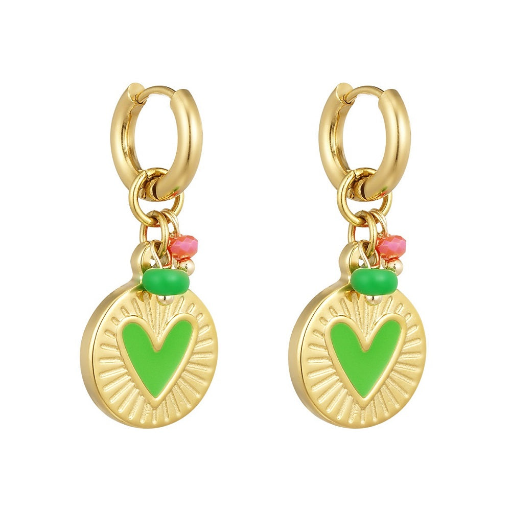 Stainless steel oorbellen goud met groene details. De oorbellen hebben een grote bedel met een groen hartje en meerdere gekleurde kraaltjes. De oorbellen zijn waterproof, stainless steel en nikkelvrij. Deze nikkelvrije oorbellen zijn te bestellen op www.jenelry.com
