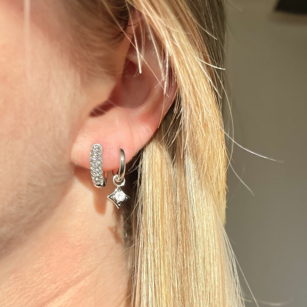 Stainless Steel Oorbellen Stardust zijn subtiel, maar toch erg feestelijk. De oorringen hebben een bedel in de vorm van een sterretje met daarop een strass steentje bevestigd. De oorbellen zijn waterproof, nikkelvrij en hypoallergeen. Oorbellen Stardust zijn verkrijgbaar in het goud en in het zilver. Bestel de oorbellen snel op www.jenelry.com