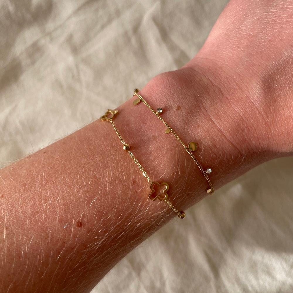 Waterproof Armband Twinkle Dot Goud, dit subtiele armbandje heeft kleine ronde bedels in verschillende formaten. Naast de ronde bedels heeft dit armbandje ook bedels met strass steentjes. Dit armbandje is erg fijn, rustig en subtiel. Het armbandje is gemaakt van stainless steel en verkleurt niet. De armband is te bestellen op www.jenelry.com