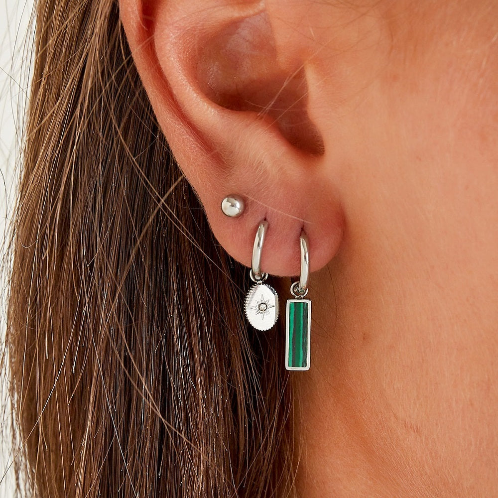 Deze waterproof oorbellen Jade hebben een ringetje met een rechthoekige bedel. De bedel heeft een groen gekleurde steen, vandaar de naam jade. De oorbellen zijn waterproof, nikkelvij en anti-allergeen. De oorbellen verlkeuren niet en blijven mooi, ook als ze in aanraking komen met water verkleuren de oorbellen niet. Bestel ze via www.jenelry.com