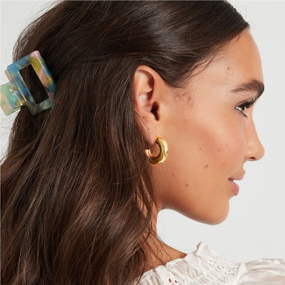 Vrouw met grove musthave oorbellen in het goud. Deze grove, chunky hoops zijn waterproof en verkleuren niet als ze in aanraking komen met water. Shop deze oorbellen nu op www.jenelry.com