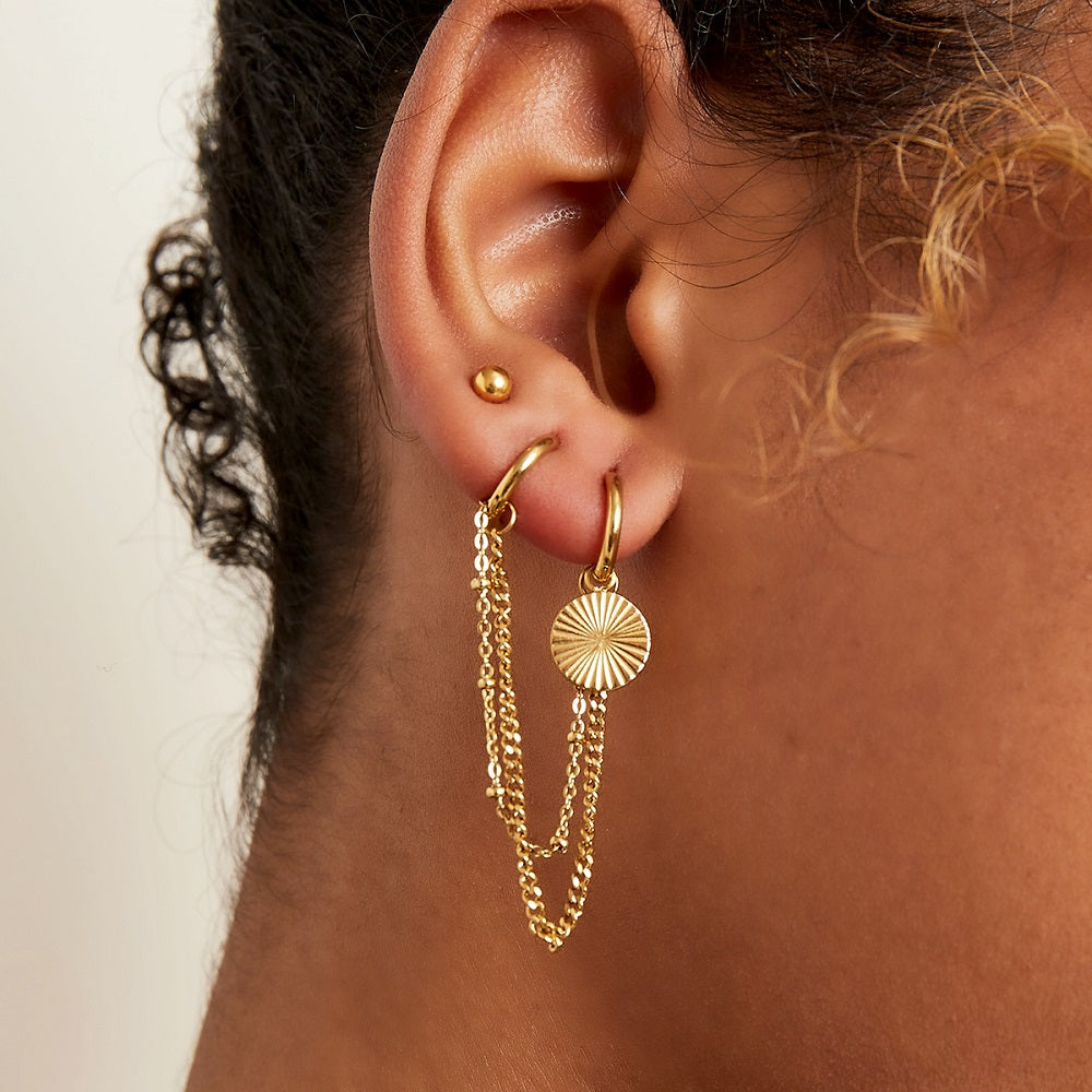 Deze waterproof oorbel bestaat uit twee oorringen, de oorringen zijn verbonden door twee kettinkjes. Aan één oorring hangt een bedel. De oorbellen zijn verkrijgbaar in het goud en in het zilver. De oorbellen verkleuren niet en blijven mooi. De oorbellen zijn te bestellen op www.jenelry.com